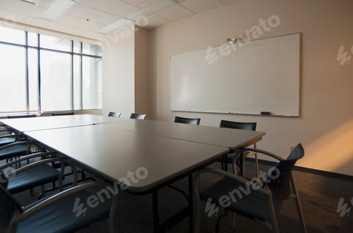 Preview: An office boardroom with table and chairs and a whiteboard on the wall.