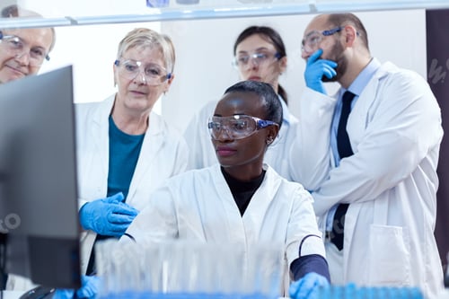 Preview: Group of scientists in medicine lab looking at computer display