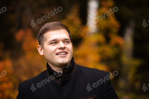 Preview: Handsome man looks in the side of autumn cool day