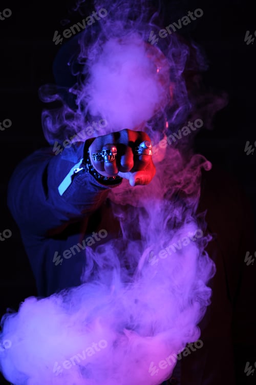 Preview: Unrecognizable man surrounded by smoke in neon lighting