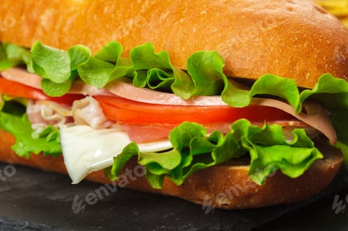 Preview: Fresh sandwich with lettuce, tomato, ham, and mayonnaise on a brown roll