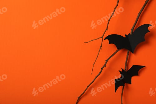 Preview: Paper bats and branch on orange background, space for text