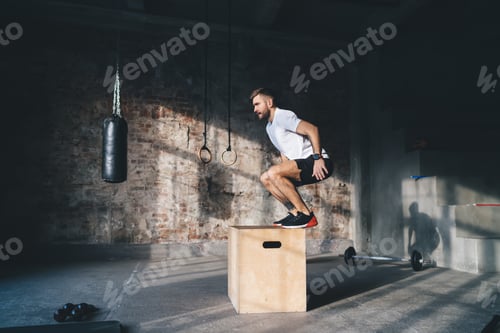 Preview: Energetic sportsman doing box jump workout at gym