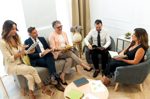 Preview: Business people having meeting using digital tablet and notebook in coworking space