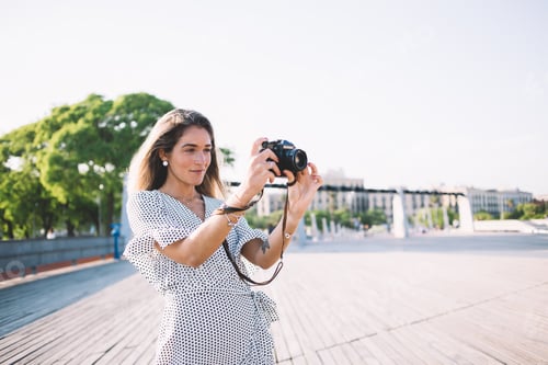 Preview: Cheerful female taking photos in summer