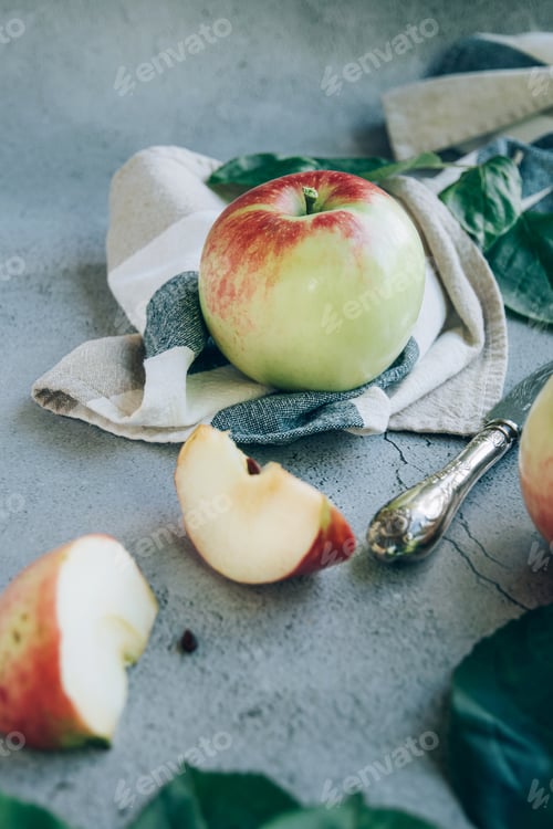 Preview: High angel view of freshly harvested ripe green red organic apples over napkin or towel and knife on