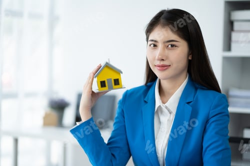 Preview: Real estate house agent showing house model to customer, real estate housing concept.