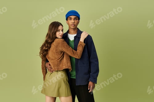 Preview: A young fashionable couple embraces in vibrant autumn outfits against a lively backdrop