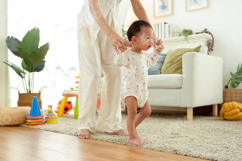 Preview: Toddler Learns to Walk With Support in a Cozy Living Room During Sunlight Hours