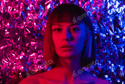 Preview: Portrait of a beautiful girl in neon light of purple, pink and blue colors.