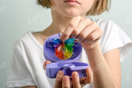 Preview: Child carefully stores colorful orthodontic retainer in case for daily hygiene