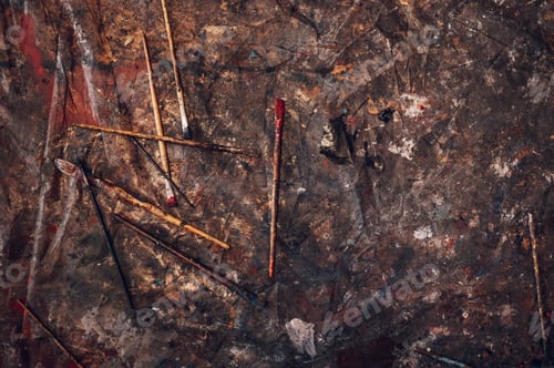 Preview: Dirty paintbrushes laying on the floor of an artist studio