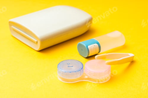 Preview: Accessories for storing lenses: a bottle of liquid, container, tweezers and case on a yellow