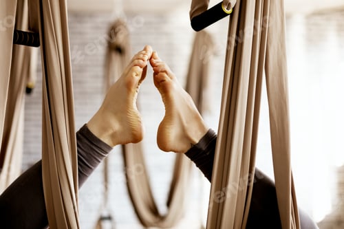 Preview: Close-up of a woman's legs in a hammock doing aerial yoga exercises in the gym
