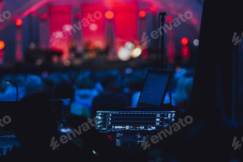 Preview: Horizontal shot of a party with lights, a stage and a turned-on computer for the DJ in a club