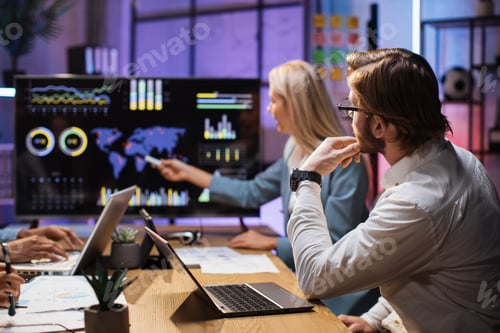 Preview: Diverse partners examining financial statistics on monitor