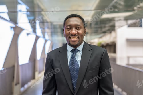 Preview: Portrait of handsome African businessman in city smiling