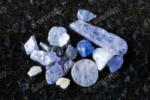 Vista previa: sample of many raw tanzanite crystals on black