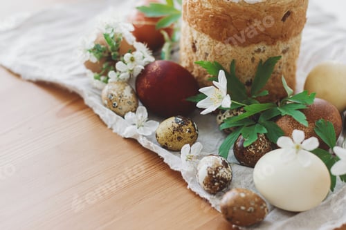 Preview: Delicious homemade Easter bread, easter eggs, spring flowers on linen napkin on rustic table