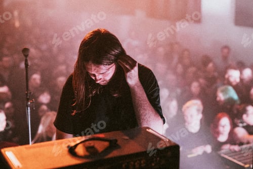 Preview: Bassist checking his ear piece at a concert
