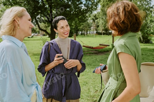 Preview: Middle Aged Women Socializing Outdoors in Park on Sunny Day