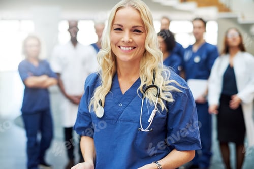 Preview: Smiling blond doctor with stethoscope in hospital