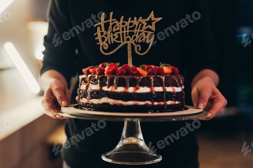 Preview: Cropped image of woman holding cake stand with chocolate cake