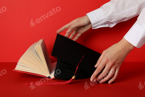 Preview: Graduate hat and books, on a red background.