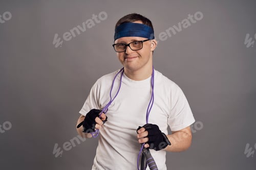 Preview: Man with down syndrome with sporty clothes on gray background