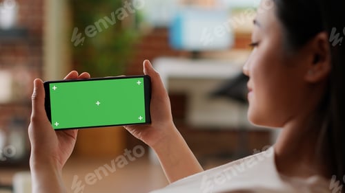 Preview: Smiling woman having smartphone with green screen chroma key background