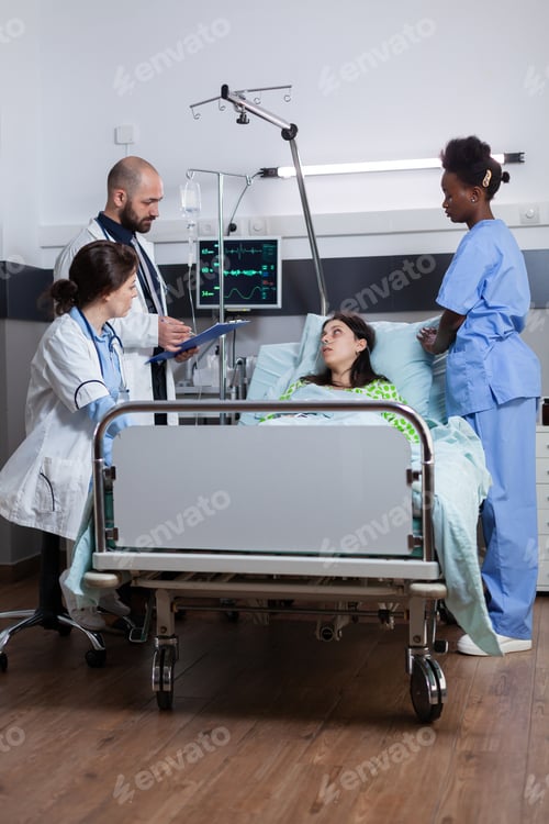Preview: Practitioners doctors checking sick woman writing disease treatment on clipboard
