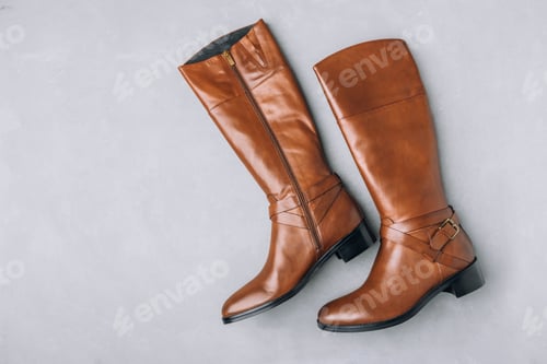 Preview: Boots. Women's brown leather high long boots on gray background. Top view.