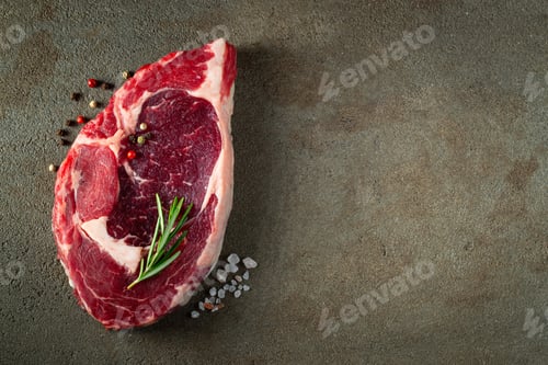 Preview: Raw ribeye beef steak with herbs and spices.