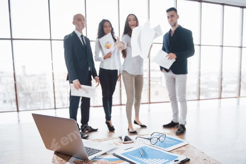 Preview: Image of business documents on workplace with partners interacting on background. Teamwork concept