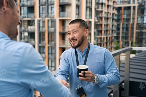 Vista previa: Empresario asiático saluda a su socio con un apretón de manos