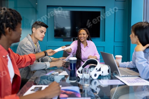 Preview: Colleagues gather as biracial woman hands document to man at a startup