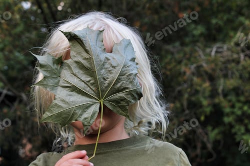 Preview: A boy hiding behind a green leaf