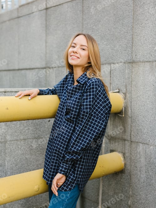 Preview: Stylish woman wearing red dress and blue shirt, black purse, walking on the street.