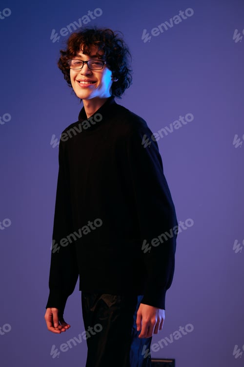 Preview: Male fashion portrait in black clothes model poses in close-up glasses, curly hair, hipster