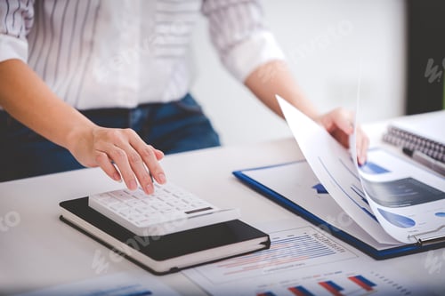 Preview: businessman or accountant who are using a calculator to calculate business data Accounting documents