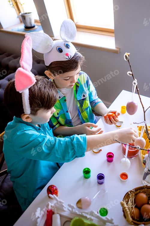 Preview: boys with bunny ears decorate willow branches with easter eggs