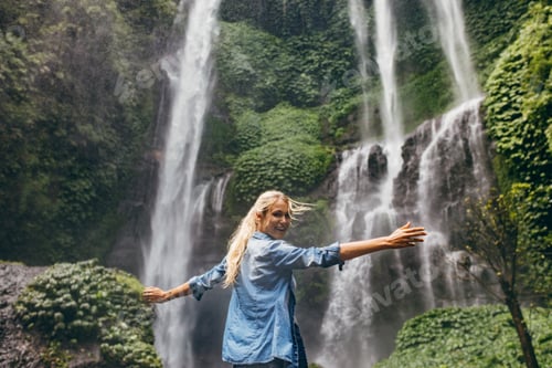Preview: Tourist enjoying by a waterfall in forest