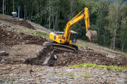 Preview: A yellow excavator works in the mountains. Construction of roads