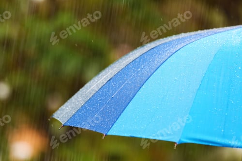Preview: Bright umbrella under rain on street, closeup