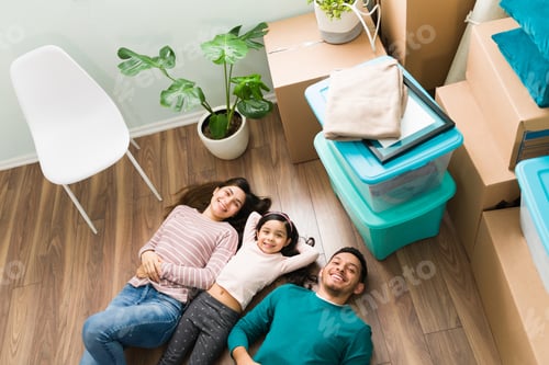 Preview: Smiling mom, dad and girl tired from unpacking