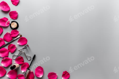 Preview: Make up accessories composition between red rose petals on grey background
