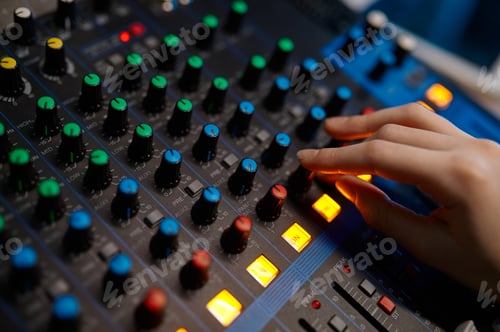 Preview: Closeup audio engineer hand on sound mixer control panel