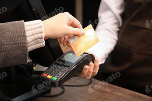 Preview: Woman with credit card using payment terminal at shop, closeup