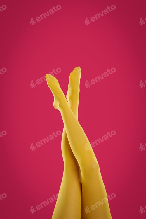 Preview: Woman wearing yellow tights on crimson background, closeup of legs