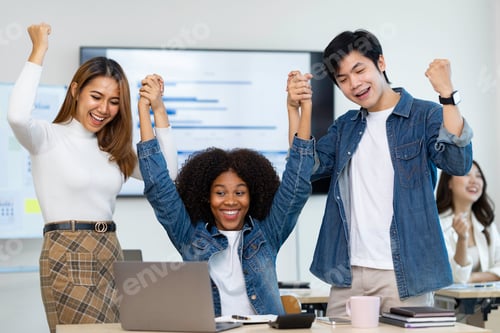 Preview: business team celebrates corporate victory together in the office, happy overjoyed professionals gro